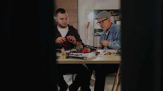 两个男工程师试图通过焊接来修复电路…视频素材