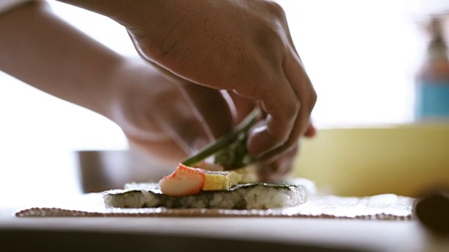 近距离拍摄厨师制作寿司卷的双手视频素材
