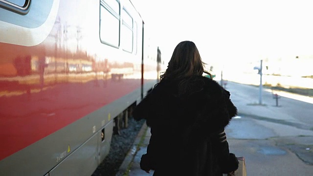 年轻女子在车站等火车。火车度假视频素材