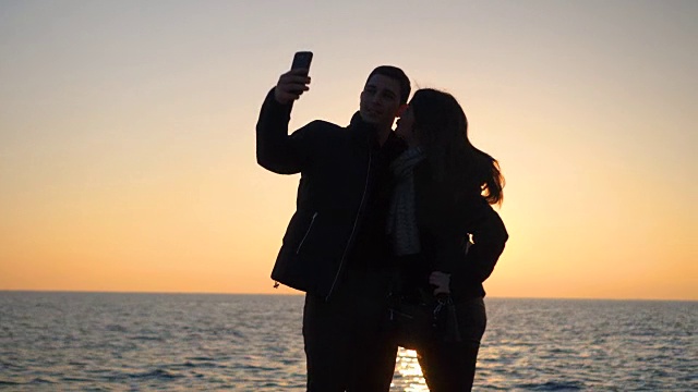 日落时分，一对情侣在海边自拍视频素材