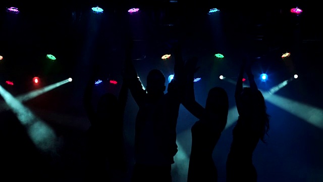 在夜总会跳舞的年轻人的剪影。视频素材