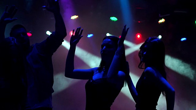 黑暗中跳舞的年轻人剪影。视频素材