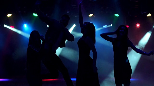 一群青少年在音乐会上在黑暗中跳舞。视频下载