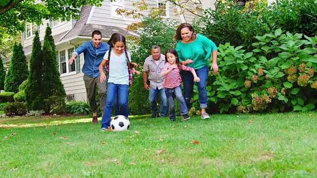 多代家庭在花园里踢足球视频素材