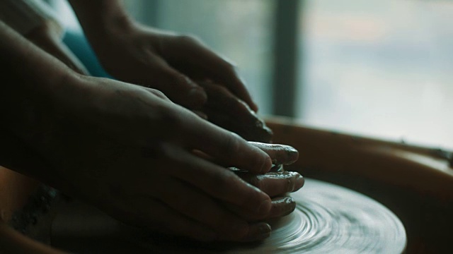 特写，男人和女人的手在粘土上用陶轮视频素材