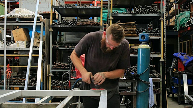 金属学徒在工厂使用电动工具视频素材