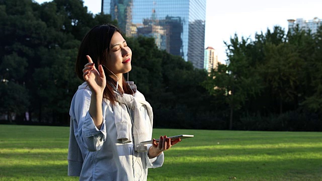 4K:美丽的亚洲女人在公园里，中国上海视频下载