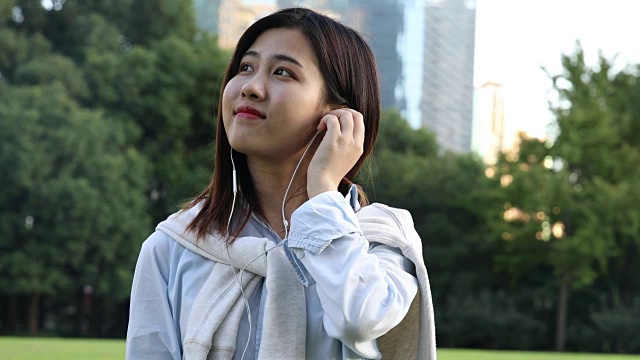 4K:美丽的亚洲女人在公园里，中国上海视频下载