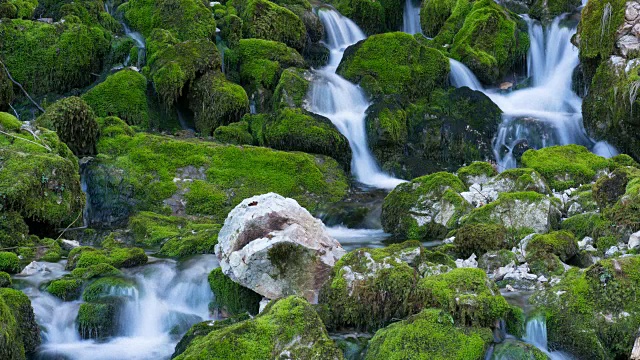 河流落在长满苔藓的石头中间视频下载