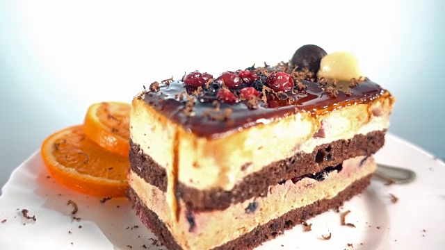 巧克力剃须落在一片水果蛋糕上，旋转，4k视频素材