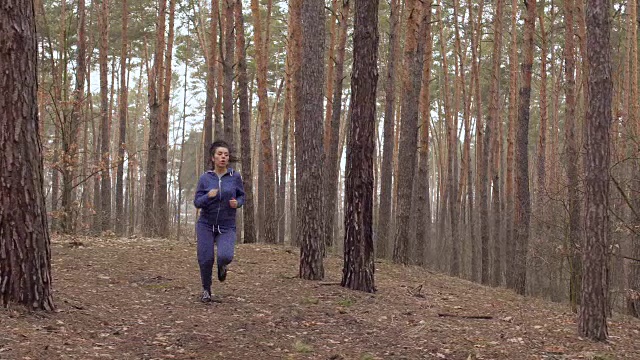 年轻漂亮的女人在森林里奔跑视频下载