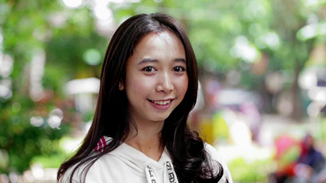 美丽的东南亚女人在镜头前微笑的肖像公园与三种色调视频素材