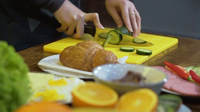 一个女人正在切黄瓜做三明治视频素材