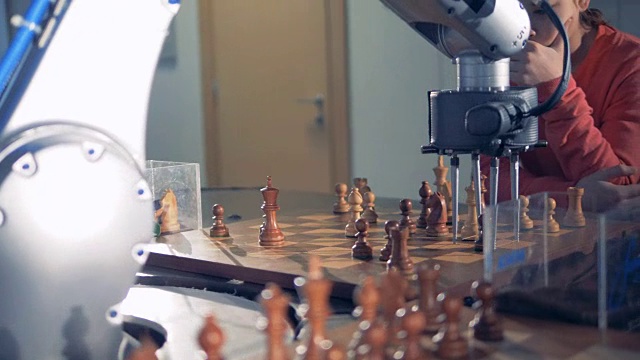 机器人和人类下棋。电脑机械手移动棋子，按下控制手表的键。视频下载
