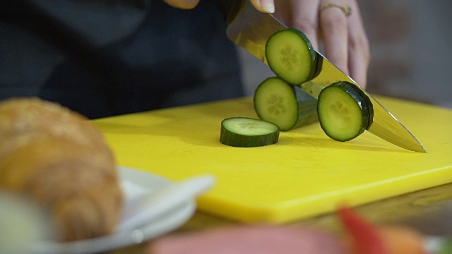 一个女人正在切黄瓜做三明治视频素材
