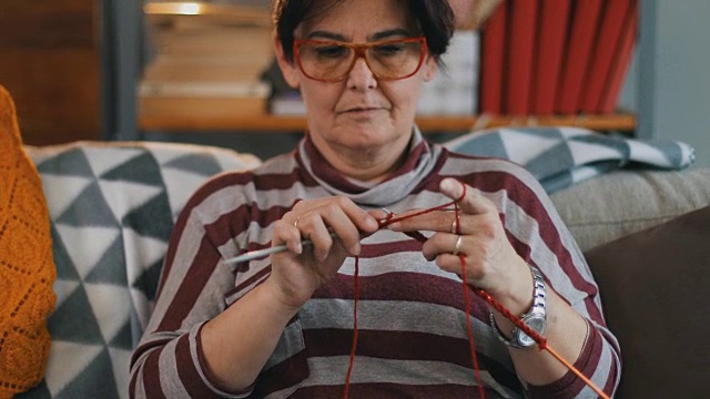 一个女人在客厅里织围巾视频素材