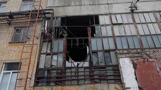 阴天拆除旧工业建筑外立面，玻璃破碎，框架被毁视频素材