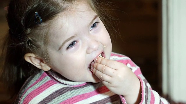 小女孩吃饼干的慢镜头视频素材