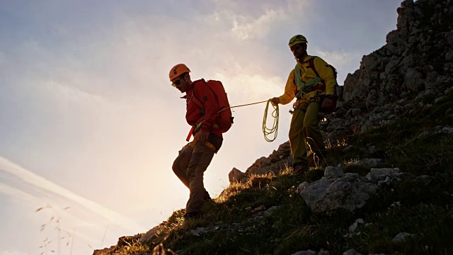 两名登山运动员在日落时分下山视频下载