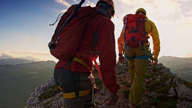 两个登山运动员在日落时到达山顶视频下载