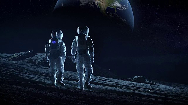 两名宇航员穿着太空服站在月球上看美丽的地球。月球殖民和太空旅行的高科技概念。视频素材