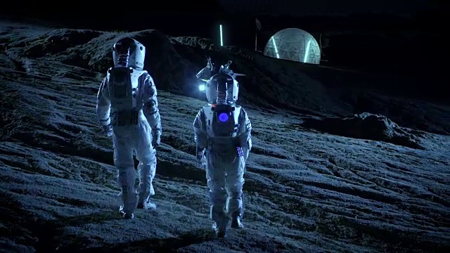 下面是两名宇航员穿着太空服行走在外星星球上仰望天空的照片。在背景基地与球型圆顶。其他世界殖民和太空旅行的概念。视频素材