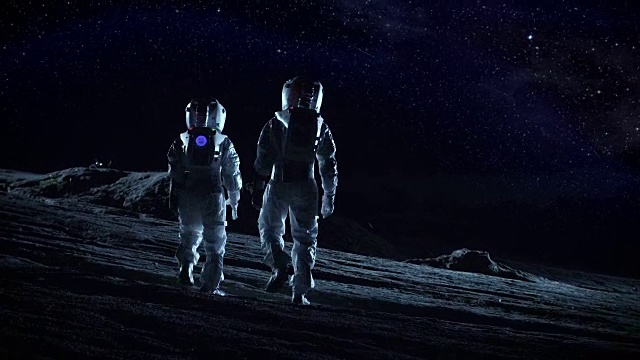 两名宇航员穿着太空服站在外星星球上看星星和星系。太空旅行和地外殖民概念。视频素材