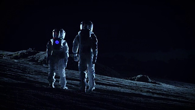 两名宇航员穿着太空服站在外星观察地外地形。太空旅行和地外殖民概念。视频素材