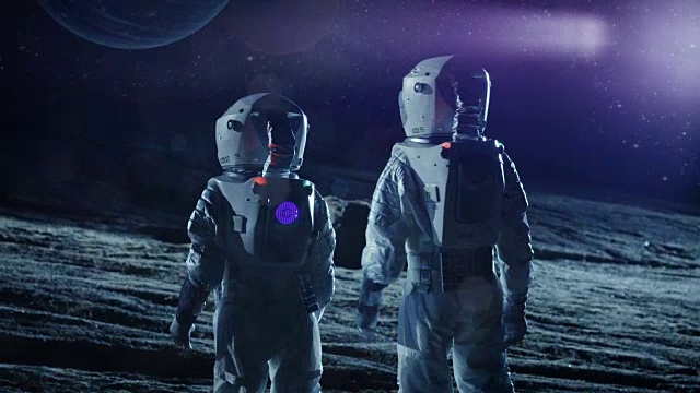 两名宇航员穿着太空服站在外星看天空中两颗美丽的行星。太空旅行，宜居世界和殖民概念。视频素材