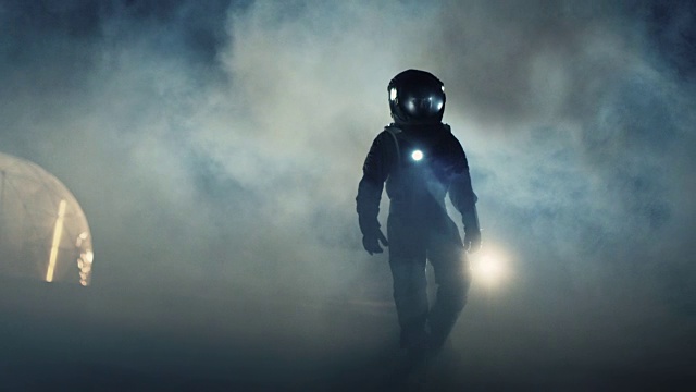 勇敢的宇航员穿着太空服手持手电筒探索迷雾中的神秘外星星球。冒险。太空旅行，宜居世界和殖民概念。视频素材