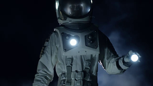 勇敢的宇航员穿着太空服手持手电筒探索迷雾中的神秘外星星球。冒险。太空旅行，宜居世界和殖民概念。视频素材