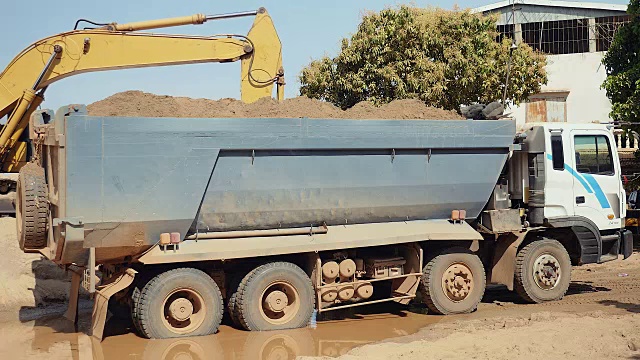 挖掘机将沙子装进自卸卡车(特写)视频素材