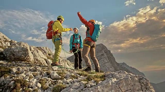 一名男性登山者登上山顶，和他的两位同事一起庆祝视频下载