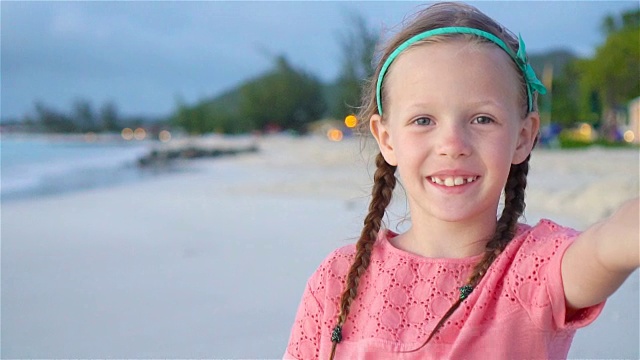 可爱的小女孩在热带白色海滩自拍。慢动作视频下载