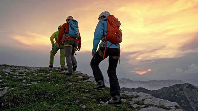 日落时分，三个登山者在山脊上行走视频下载