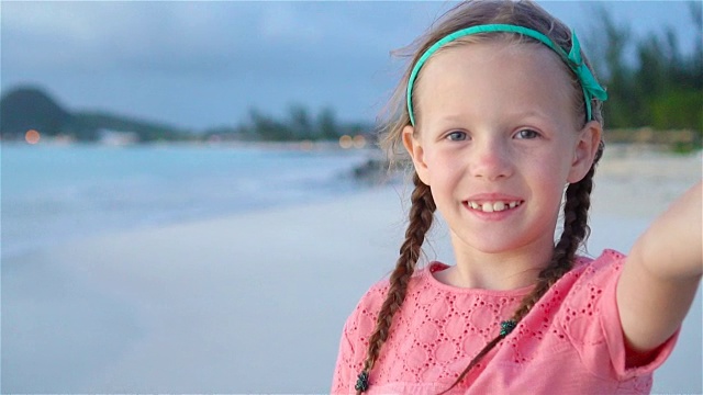 快乐的小女孩在暑假期间在异国情调的岛屿热带海滩自拍视频下载