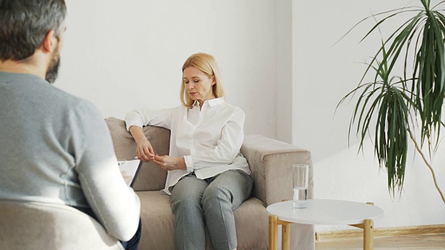 成年压力女性抑郁症与男性专业精神分析学家在心理治疗办公室室内交谈视频素材