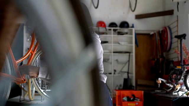 一名妇女在自行车修理店用工具和螺丝钉组装一辆老式自行车视频下载