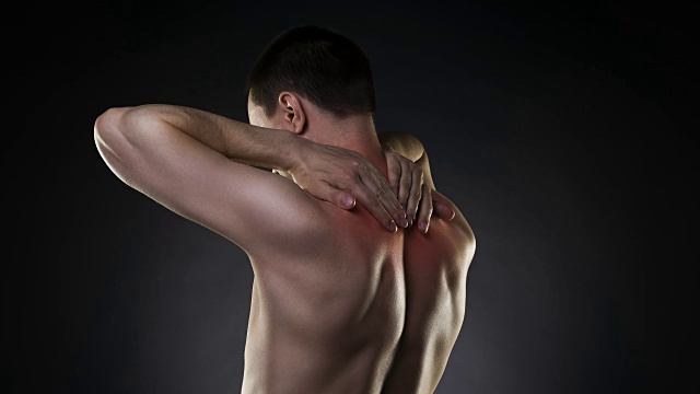 颈部疼痛，背部疼痛的男人在黑色背景视频素材