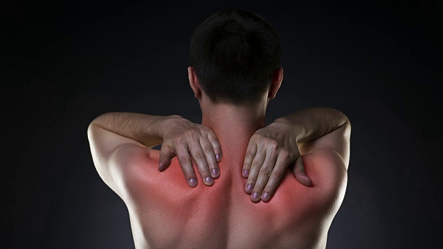 颈部疼痛，背部疼痛的男人在黑色背景视频素材