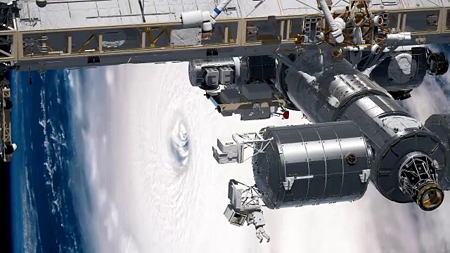国际空间站围绕地球大气层旋转。飓风在后面。视频素材