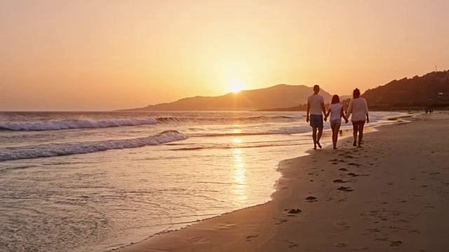 日落时分一家人在沙滩上散步视频素材