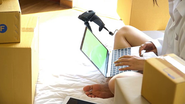 高角度摄影:年轻的亚洲妇女在笔记本电脑上做小生意视频下载