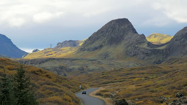 独特的冰岛景观，熔岩地，小山，蜿蜒的道路和移动的汽车，在秋天的一天视频下载