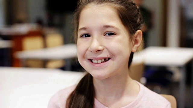 学校教室里快乐微笑的小女孩的肖像视频素材