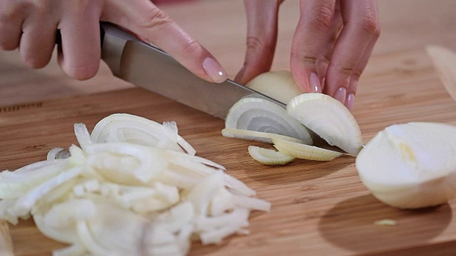 厨师把洋葱切成片。刀，切菜板，洋葱。视频素材