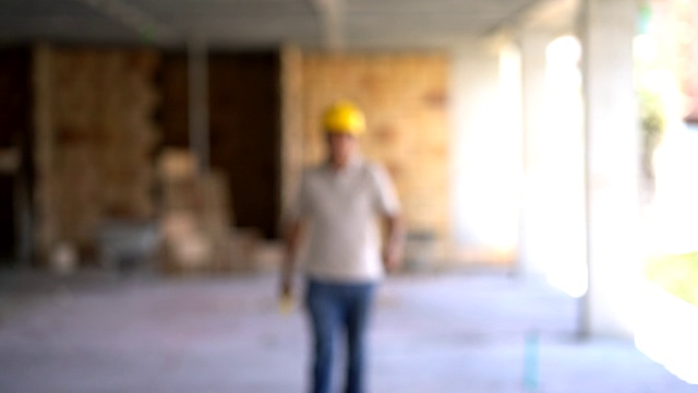 一个建筑工地的年轻工人拿着一根杠杆微笑着走向镜头视频素材