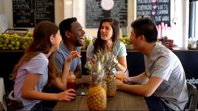 多民族的朋友群在果汁吧有有趣的谈笑，同时享受果汁视频素材
