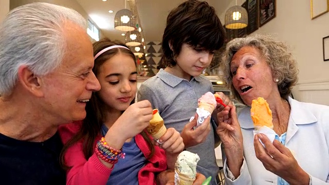 孙辈们和他们的祖父母分享他们的冰淇淋，看起来都非常高兴和微笑视频素材