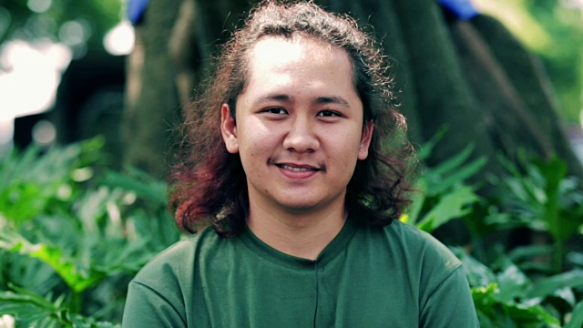 帅气的东南亚年轻男子在镜头前用三种色调微笑(蓝-橙，对比和原始)视频下载